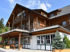 Una cabaña de madera con balcón, un porche cubierto y un cartel que indica que es un restaurante.