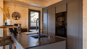A modern kitchen with a granite countertop, stainless steel appliances, and wooden cabinetry.