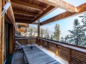 A wooden deck with a view of snow-covered trees and mountains. - Chalet in Alps With Sauna Near Ski Slopes (Stadl-Predlitz)