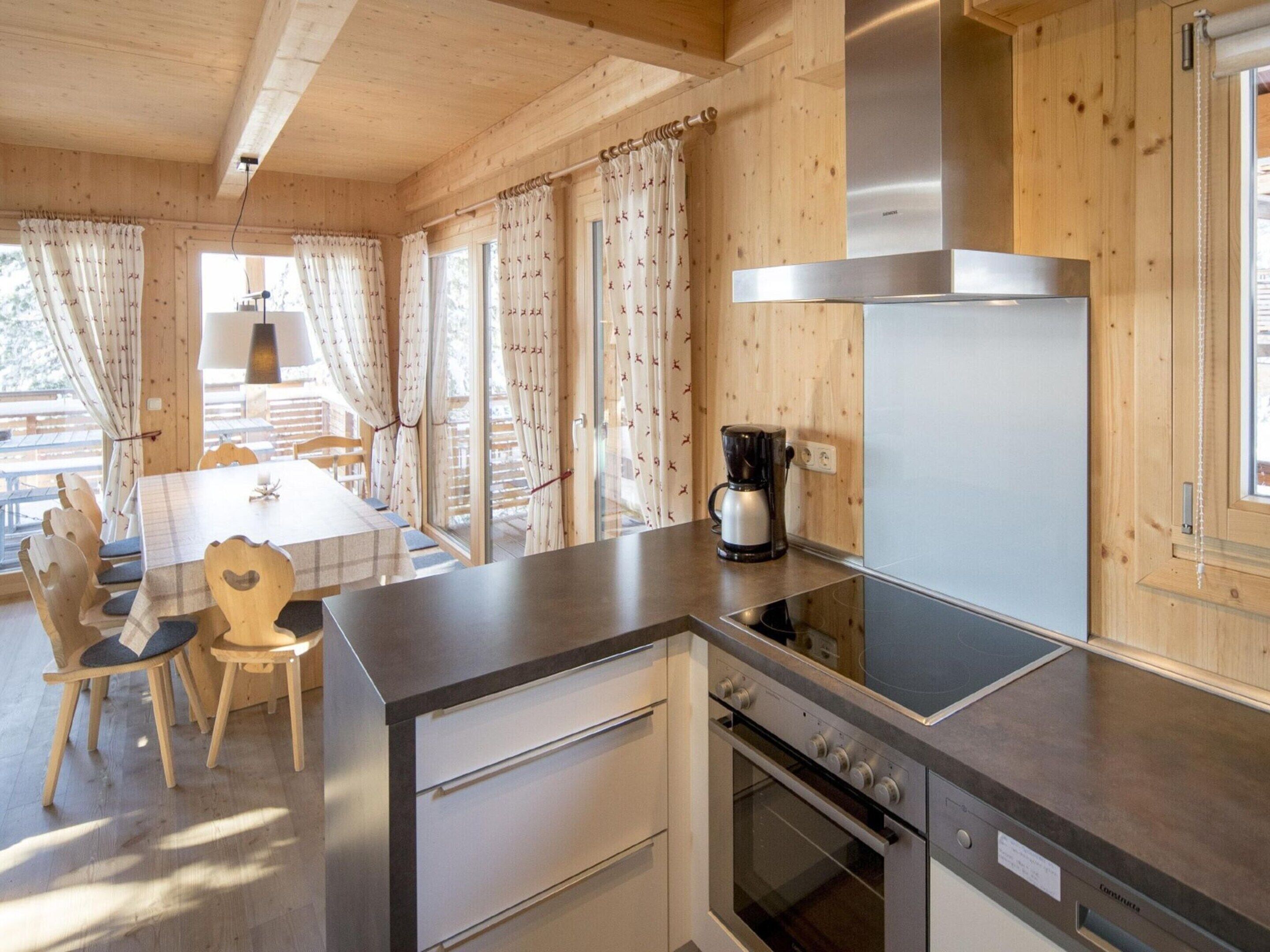 A modern kitchen with wooden cabinetry, a built-in oven, and a coffee maker on the counter.