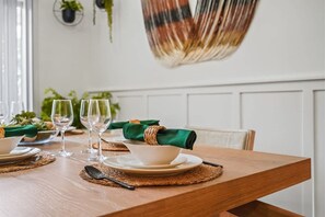 A dining table set with plates, glasses, and a green napkin.