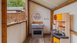 A compact kitchen with a small oven, a sink, and a toy kitchen set. - Stunning 3BR Home-Backyard HOT TUB Oasis-Home Gym (Boise)