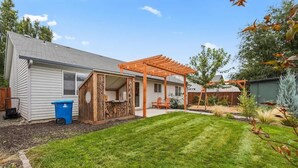 A backyard with a wooden pergola, a lawn, and a shed. - Stunning 3BR Home-Backyard HOT TUB Oasis-Home Gym (Boise)