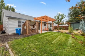 A backyard with a wooden pergola, a lawn, and a shed. - Stunning 3BR Home-Backyard HOT TUB Oasis-Home Gym (Boise)