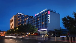 Un hôtel à étages, doté d’une enseigne lumineuse et d’une architecture moderne.