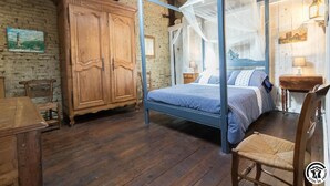 Um quarto rústico com cama de dossel, guarda-roupa de madeira e uma cadeira.