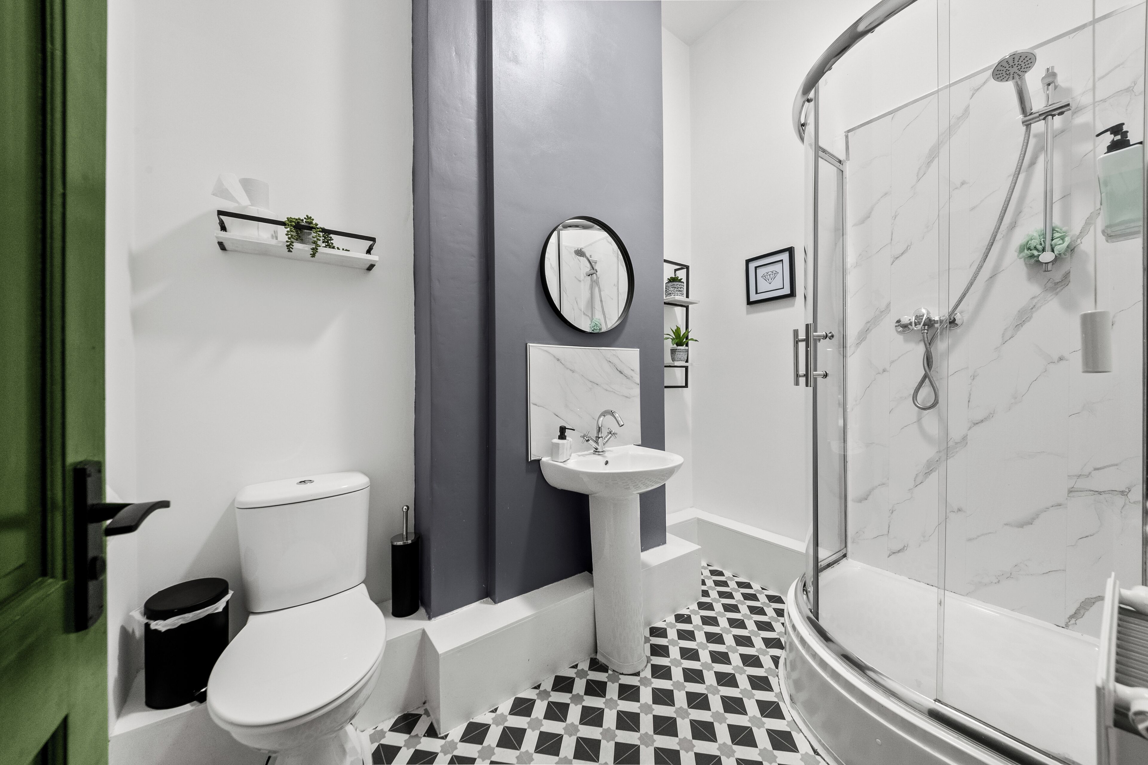 A bathroom with a toilet, sink, and shower.