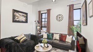 A modern living room with a sofa, coffee table, and artwork.