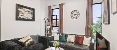 A modern living room with a sofa, coffee table, and artwork.
