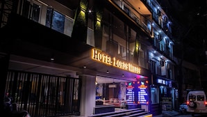 A hotel with a prominent sign, a staircase leading to the entrance, and a visible restaurant and cafe area. - Hotel Lords Valley Rishikesh (Rishikesh)