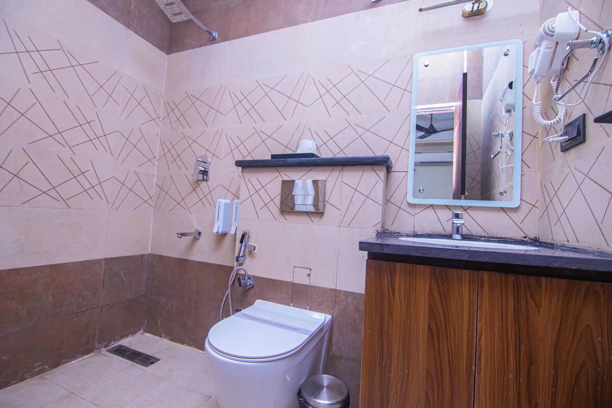 Ein Badezimmer mit Toilette, Waschbecken, Spiegel und Handtuchhalter.