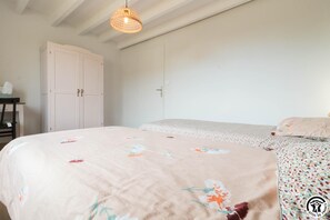 Une chambre à coucher avec un lit, une armoire et un luminaire suspendu.