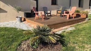 A building with a wooden deck, outdoor seating, and a small garden area. - Gîte La Selve d'Autan - Caraman (Caraman)