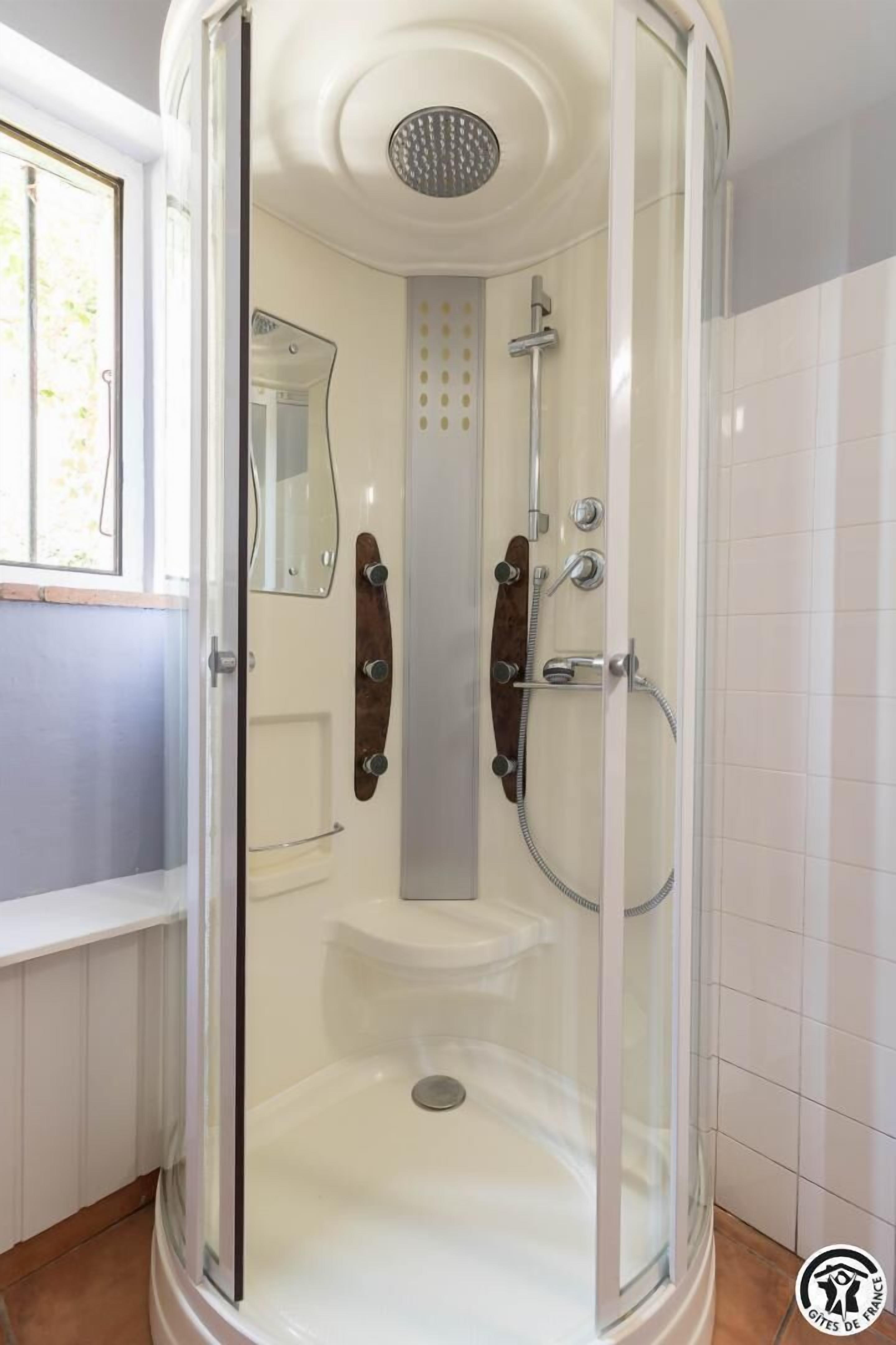 Une salle de bain moderne avec une douche à parois de verre, des toilettes et un meuble-lavabo avec un miroir.