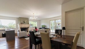 A spacious living area with a fireplace, dining table, and comfortable seating. - Villa Les Paradoux - Pin-Balma (Pin-Balma)