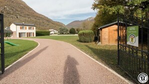 Ein gepflegter Schotterweg führt zu einem verschlossenen Eingangsbereich mit einem Schild für Gîte Haute-Garonne.