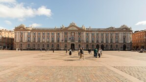 A large historic building with a central courtyard, featuring classical architecture and a clock tower.