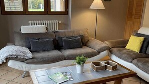 A living room with a sofa set, a coffee table, and a floor lamp. - Gîte des Cyprès - Bérat - Gîte (Bérat)