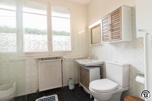 Et badeværelse med toilet, vask og vindue.