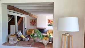 A cozy living room with a fireplace, two sofas, a coffee table, and a lamp.