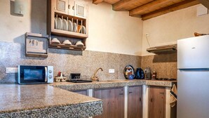 Eine Küche mit Granit Arbeitsplatten, integriertem Mikrowellenherd, einer Kaffeemaschine und Holzschränken.