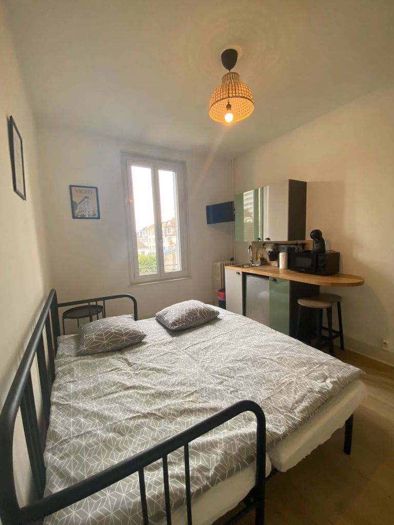 Un dormitorio con cama, escritorio y ventana.