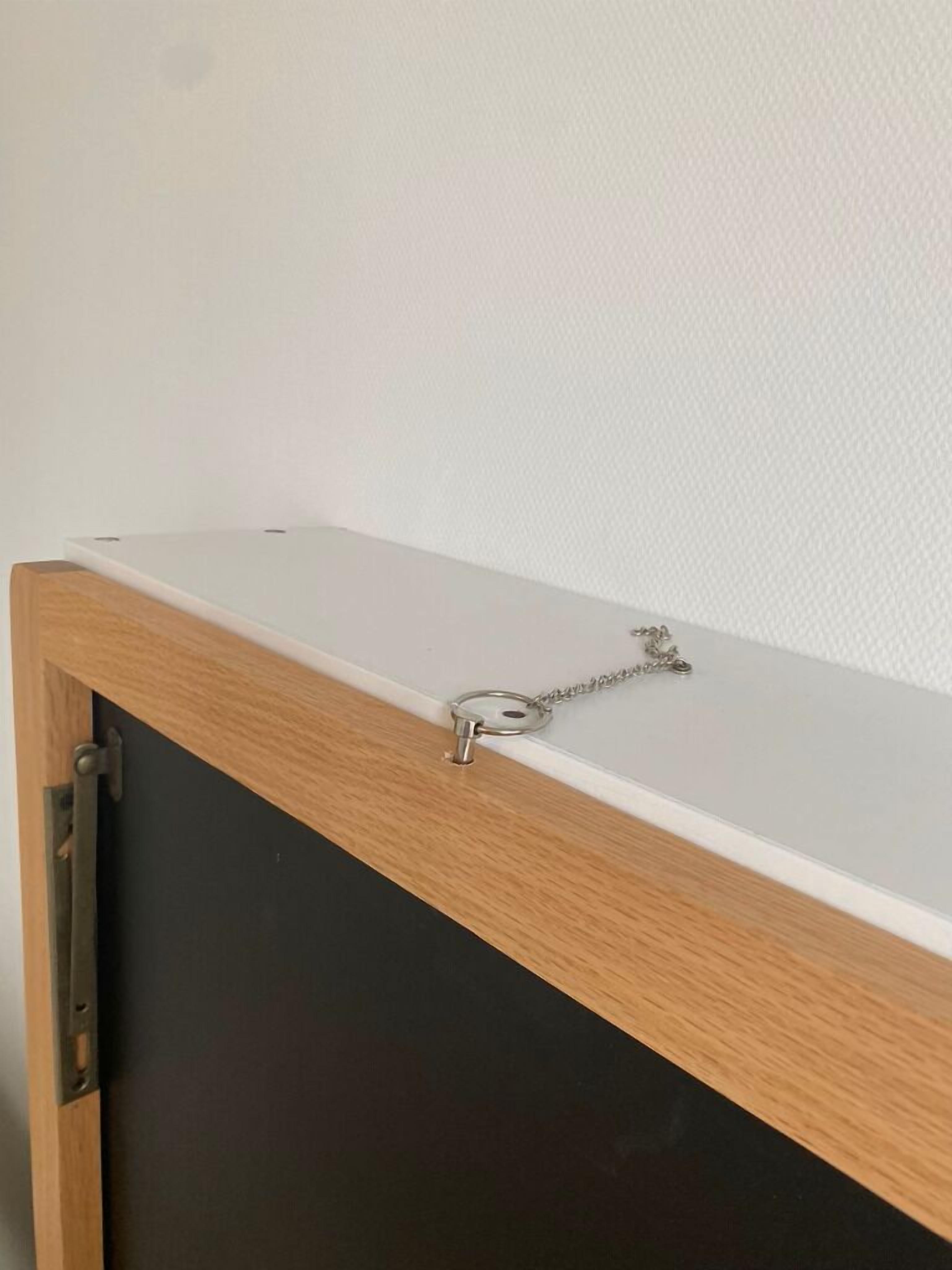 Um armário de madeira com tampo branco e porta preta.