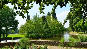 A serene park with a river, stone walls, and lush greenery. - Les Sources Vichy  (Vichy)