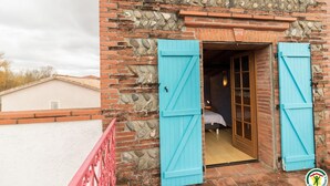 Ein rustikales Gebäude mit Steinaußenwand und einer Holztür mit blauen Fensterläden.