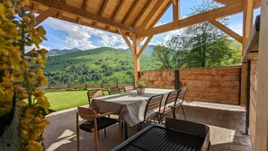 A wooden pergola with a table and chairs, overlooking a mountainous landscape. - Pyrenean chalet Fryo - Poubeau (Poubeau)