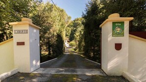 A gated entrance with a sign reading "CABANIS" and another sign with "Gîte" and a logo.