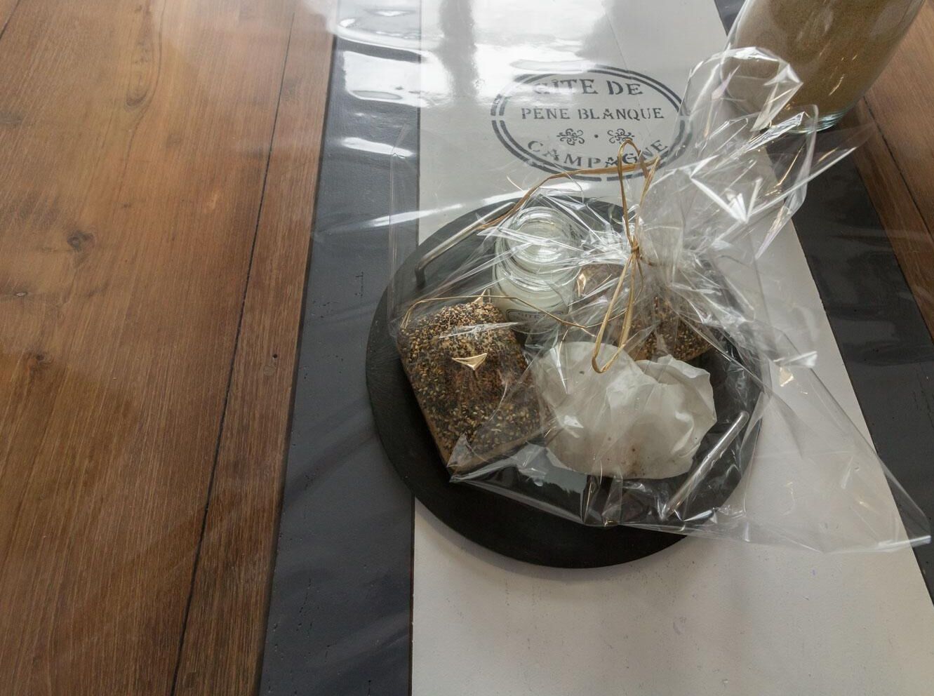 A table with a placemat and a glass container with a label.