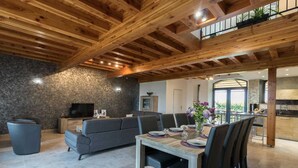 Ein modernes Interieur mit Essbereich, Wohnzimmer mit Sofa und Küche.