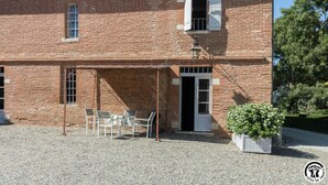 A brick building with a covered patio, a door, and a window.