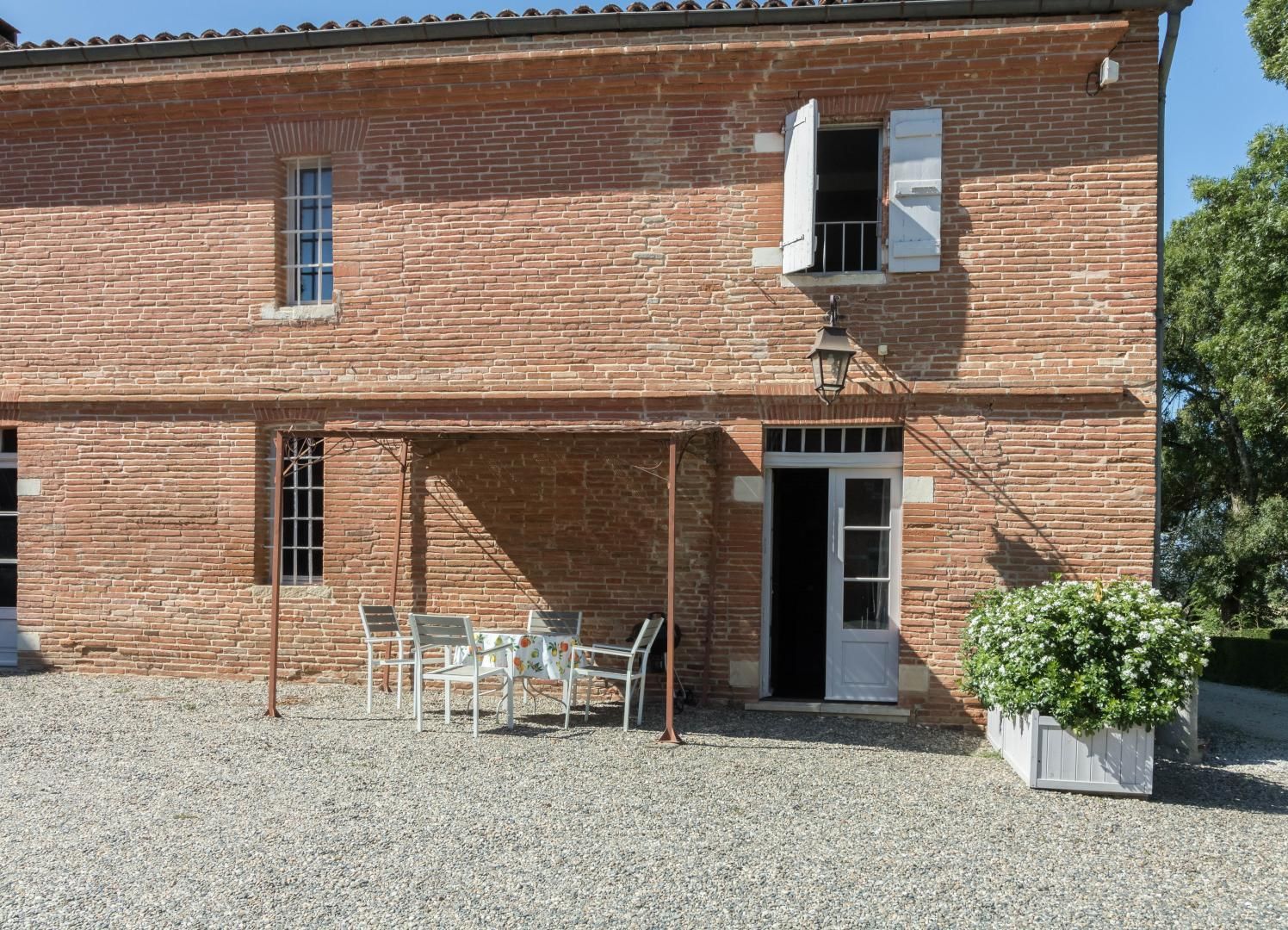 A brick building with a covered patio, a door, and a window.