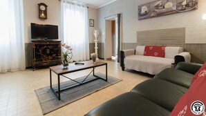 Ein modernes Wohnzimmer mit einer Couch, einem Couchtisch, einem Fernseher und einem Gemälde an der Wand.
