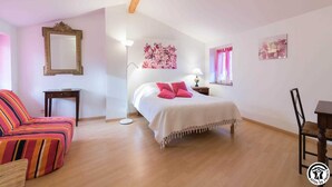 Une chambre à coucher avec un lit, une chaise, un bureau et une lampe.