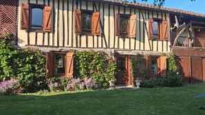Una casa tradizionale a graticcio con un giardino curato e un cancello in legno.