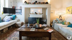 Ein gemütliches Wohnzimmer mit Kamin, Fernseher und Bücherregal.
