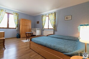 Cozy retreat with a large bed, wooden wardrobe, and a small table for a comfortable stay.