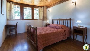 A bedroom with a wooden bed, a desk, and two bedside lamps. - Borde Basse - L'HERM - Gîte (LHERM)