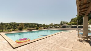 A rectangular swimming pool with a tiled deck, surrounded by greenery and trees. - La Ferme de Menoun - Thil (Thil)