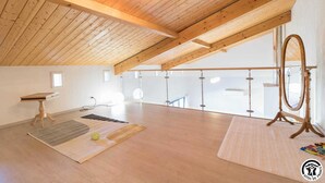 A spacious attic room with wooden beams, a large mirror, and a view of the sky. - Vignes - Saint-Léon - Gîte (Saint-Léon)