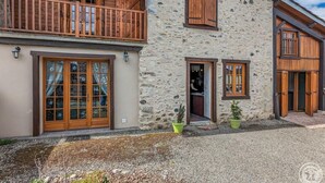 A stone building with wooden balconies, large windows, and a gravel driveway. - Le Castel Vert - Valcabrère (Valcabrère)
