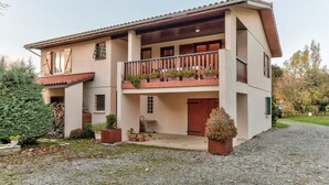 A two-story building with a balcony, a covered porch, and a gravel driveway. - Farguettou - NAILLOUX (NAILLOUX)