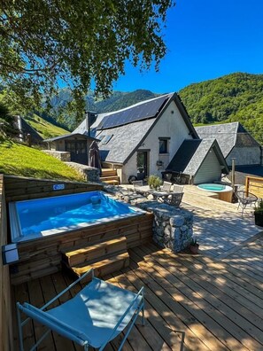 A wooden deck with a hot tub, outdoor seating, and a pool. - Chalet le René-Sens - BOUTX (COULEDOUX)
