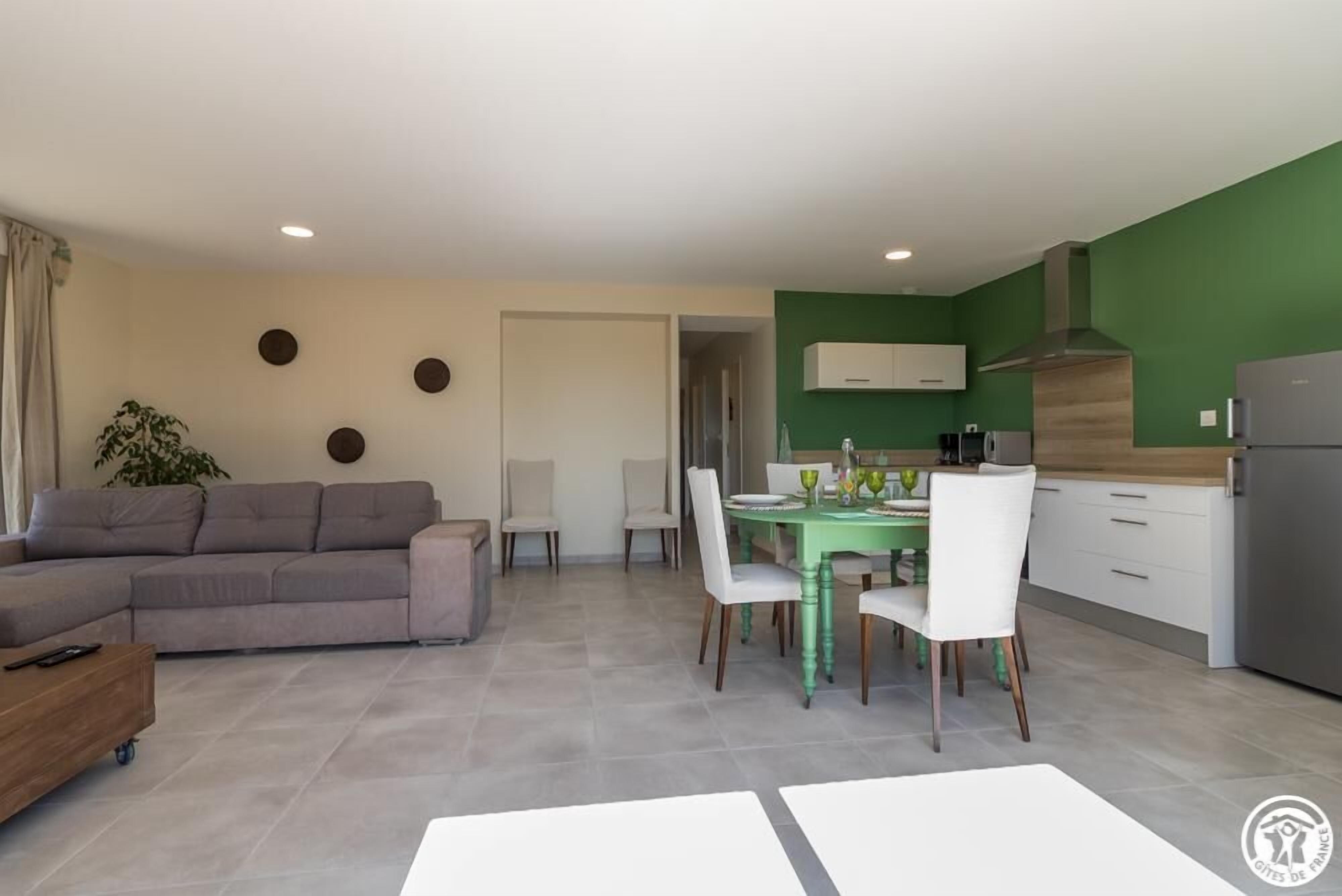 Un appartement moderne comprenant un espace de vie, un coin repas et une cuisine.