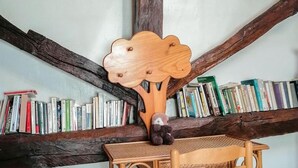 A wooden chair with a woven seat and backrest, positioned under a wooden beam structure. - La Grande Ourse - Montespan (Montespan)