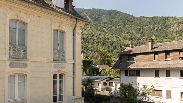 A historic building with classical architecture, including ornate window frames and a balcony with decorative ironwork. - Vacations Cures Luchon (Bagnères-de-Luchon)