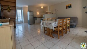 A kitchen with a dining table, chairs, a refrigerator, and a sofa. - Quioussac - Montégut-Lauragais (Montégut-Lauragais)